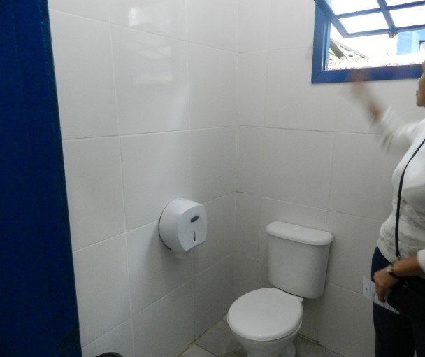 Diretora mostra banheiro reformado com dinheiro das multas