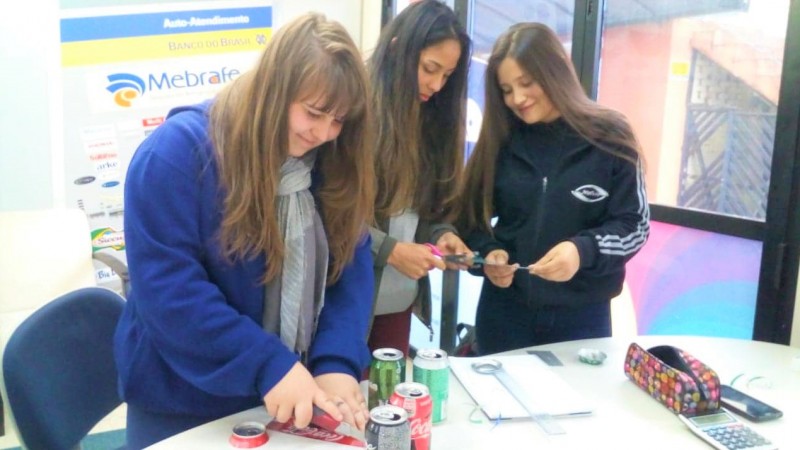 Estudantes da Escola Melvin Jones, de Caxias do Sul, expondo as embalagens adaptadas em braile