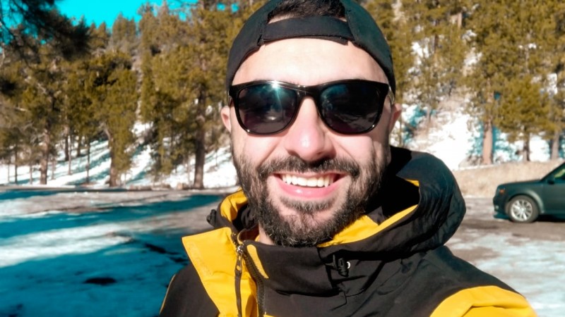 Foto de Felipe de óculos escuros sorrindo em um lugar com neve