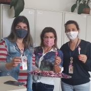 Foto das servidoras segurando as canetas com fuxicos cor de rosa