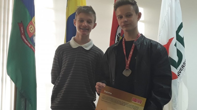 Foto de Andrei e Daniel recebendo o diploma de certificação da Obmep