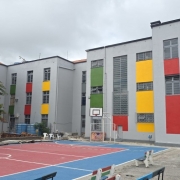 Prédios e pátio com cancha de esporte com novas pinturas