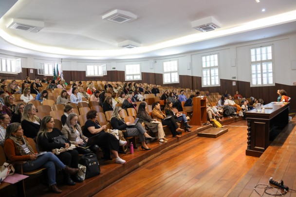 Imagem mostra auditório onde o encontro aconteceu. Pessoas sentadas na platéia.