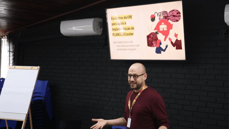Imagem de homem caucasiano de &oacute;culos apresentando PowerPoint sobre os PLANCONs